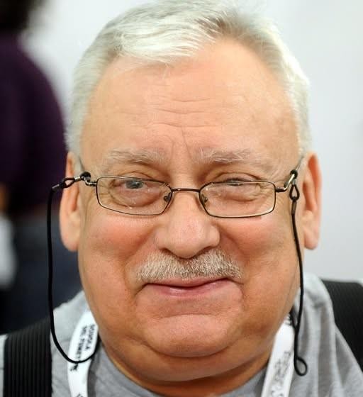 Grafika przedstawiająca elementy ze świata Wiedźmina Andrzeja Sapkowskiego, z subtelnym nawiązaniem do Geralta z Rivii i tłem inspirowanym adaptacjami.