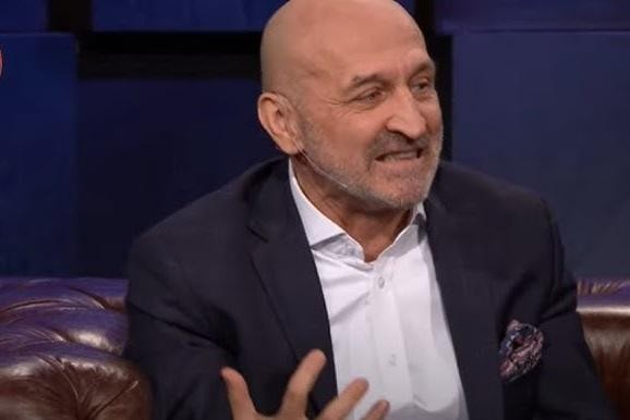 Kazimierz Marcinkiewicz w rękawicach bokserskich, w dynamicznej pozie w ringu, symbolizującej jego udział w charytatywnej walce bokserskiej.