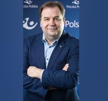 Sebastian Mikosz, menedżer i ekonomista, na tle symbolizującym jego karierę w lotnictwie i obecną rolę w Poczcie Polskiej.
