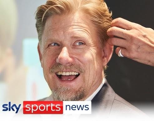 Peter Schmeichel w bramkarskim stroju Manchesteru United, skaczący do parady na tle zielonej murawy.