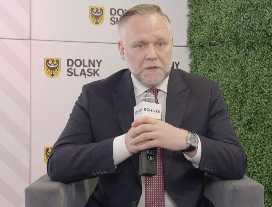 Czapka absolwenta i dyplom na stosie książek politologicznych, symbolizujące wykształcenie i początek kariery politycznej.
