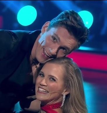 Agnieszka Kaczorowska w naturalnej, codziennej sytuacji, uśmiechnięta, co podkreśla jej rolę matki i aspekty życia prywatnego.