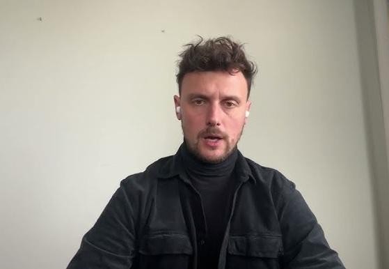 Alt: Łukasz Grabarczyk, neurochirurg i wykładowca, podczas prezentacji lub szkolenia medycznego.