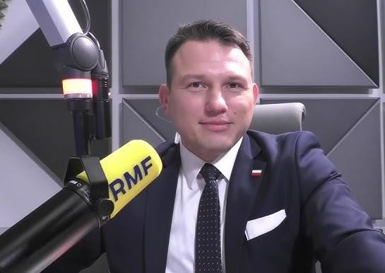 Sławomir Mentzen podczas spotkania z wyborcami, uśmiechnięty i zaangażowany w interakcję.