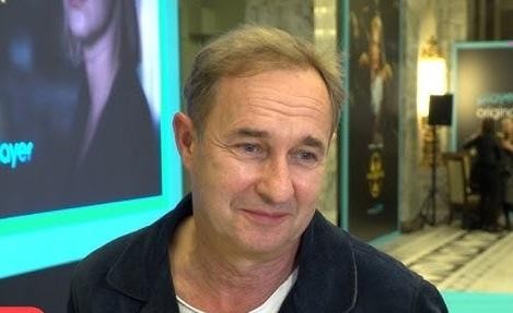 Marek Kalita spacerujący po Puszczy Kampinoskiej, zamyślony, w otoczeniu zieleni, symbolizujący jego związek z naturą i prywatnością.