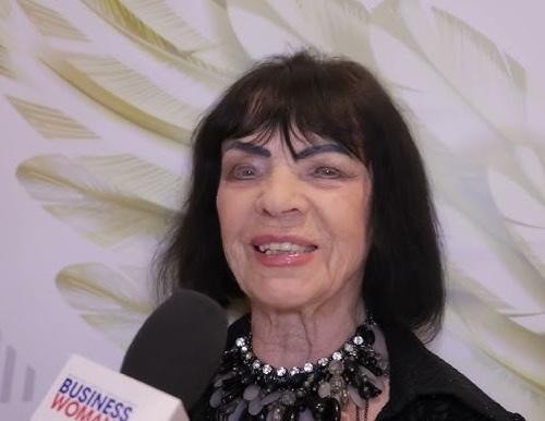 Sława Przybylska na scenie w czarno-białym ujęciu, śpiewająca do mikrofonu i trzymająca gitarę, z intensywnym wyrazem twarzy.
