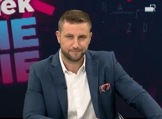 Miłosz Kłeczek podczas ożywionej dyskusji w studiu telewizyjnym, z widocznym napięciem i gestykulacją.